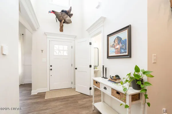 a living room with stainless steel appliances kitchen island granite countertop furniture and a chandelier