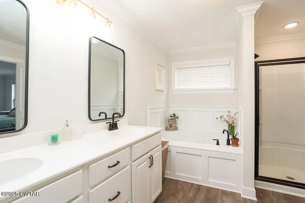 a bathroom with a double vanity sink window and a bathtub