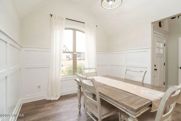 a dining room with a window and wooden floor