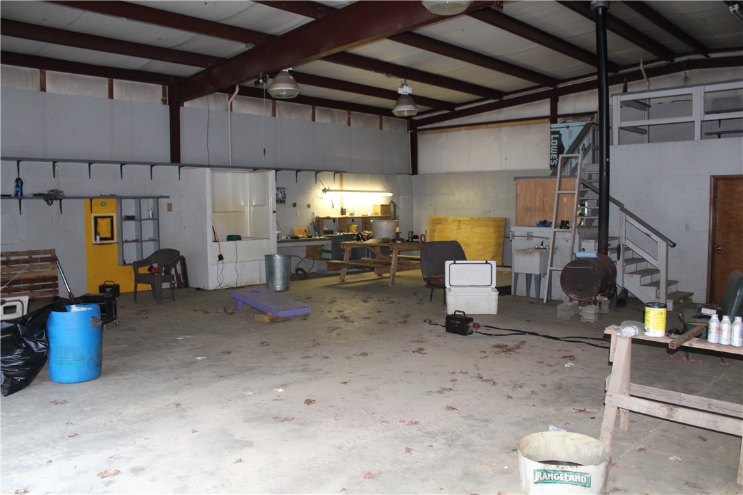 158 Ragon Road Tilly, AR 72679 - Photo 34 of 51 Expansive open workspace with concrete flooring, exposed beam ceiling, and a built-in staircase leading to an upper level
