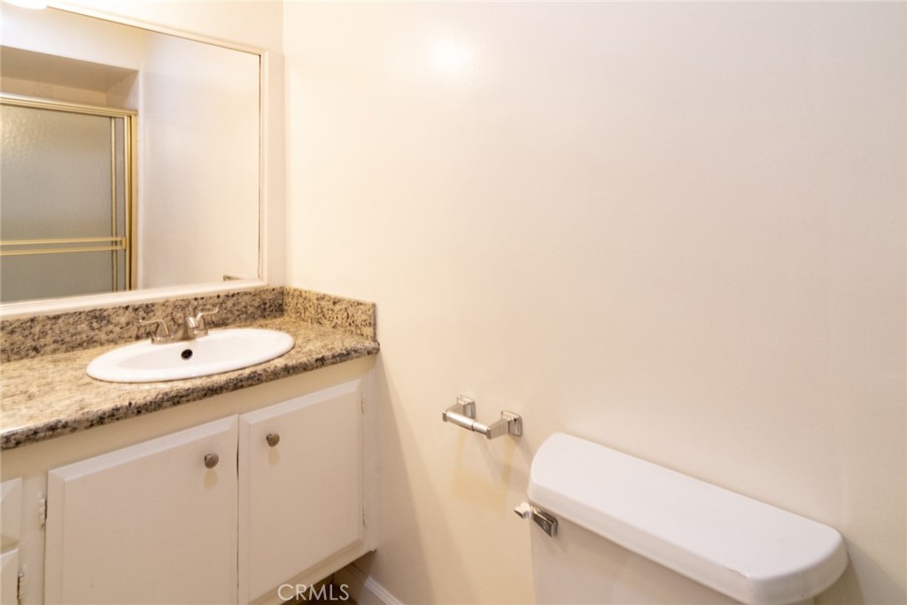 1122 9th Street, Unit 4 Santa Monica, CA 90403 - Photo 16 of 18 a bathroom with a granite countertop sink and a mirror