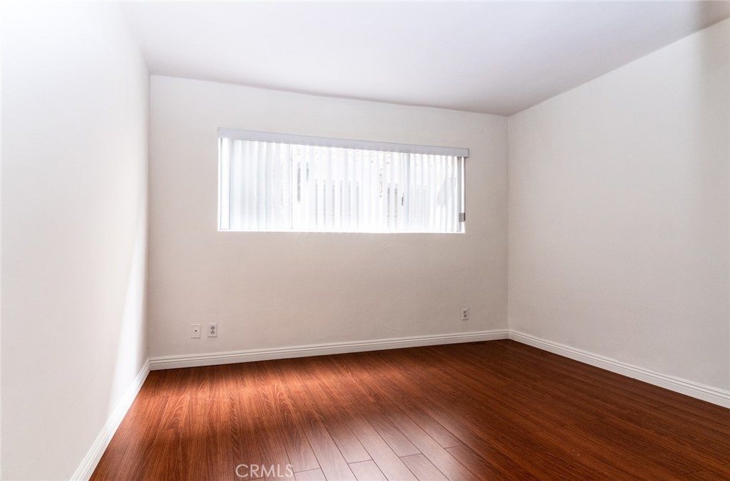 1122 9th Street, Unit 4 Santa Monica, CA 90403 - Photo 17 of 18 an empty room with wooden floor and windows