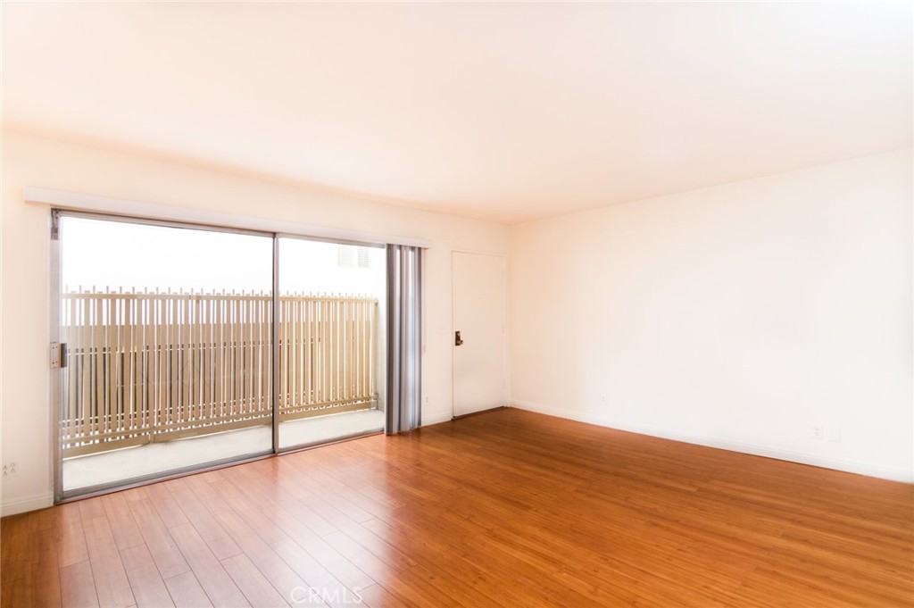1122 9th Street, Unit 4 Santa Monica, CA 90403 - Photo 3 of 18 an empty room with wooden floor and windows