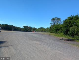 Spacious gravel lot under clear skies.