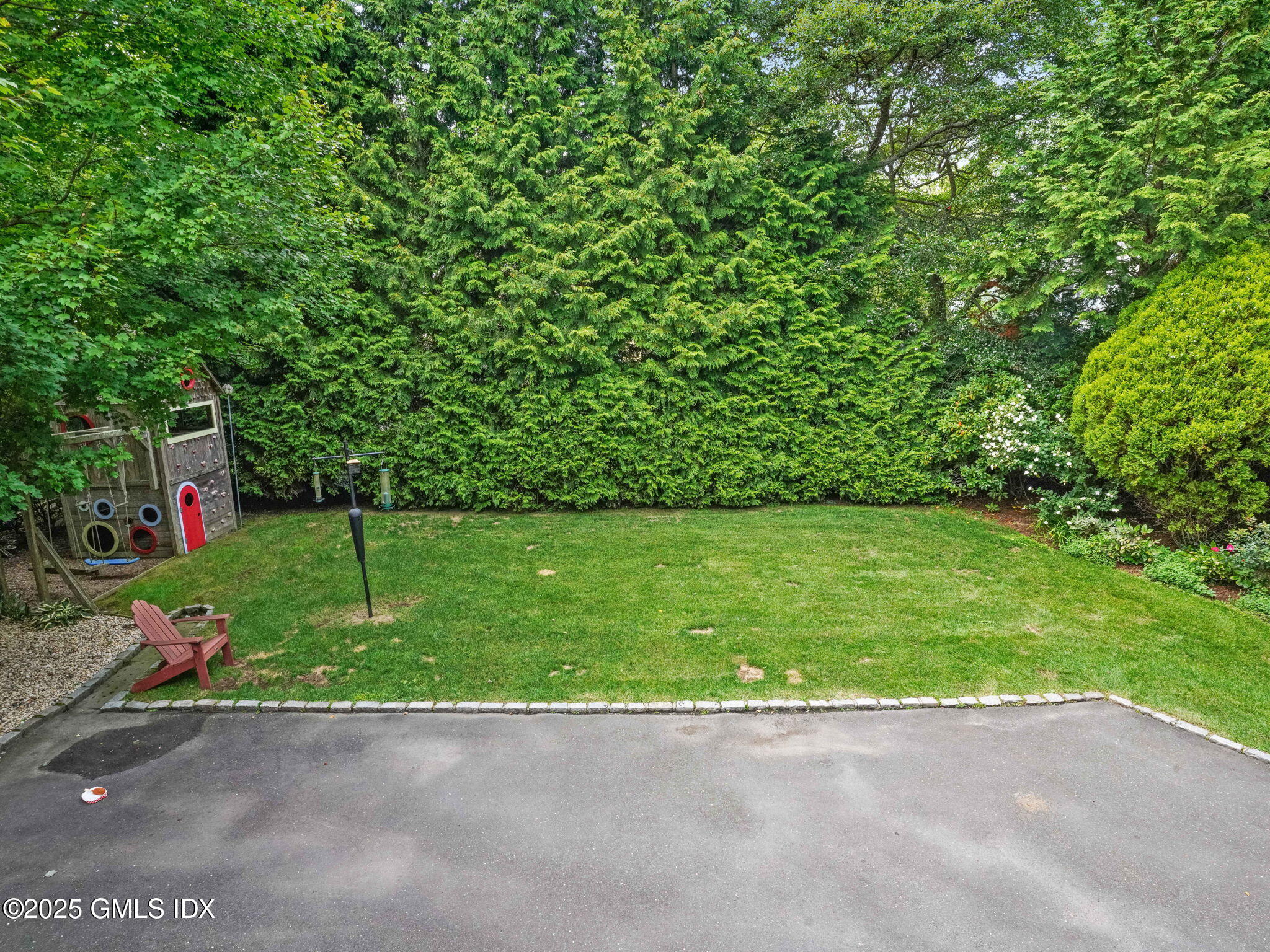 143 Lockwood Road Riverside, CT 06878 - Photo 35 of 39 a view of a street with a small yard and a large tree
