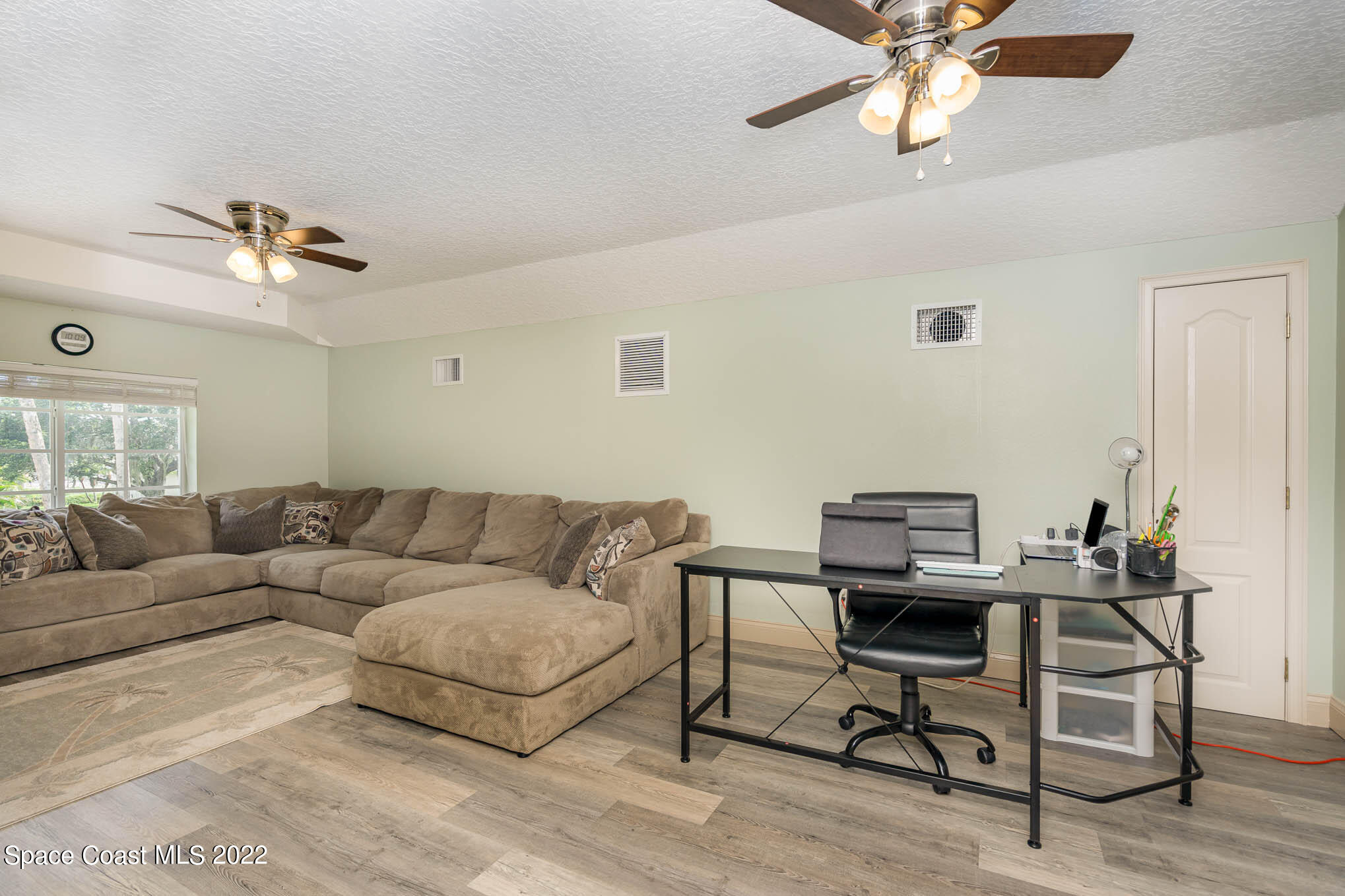 762 Seymour Road Northeast Palm Bay, FL 32905 - Photo 11 of 29 a living room with furniture and a ceiling fan