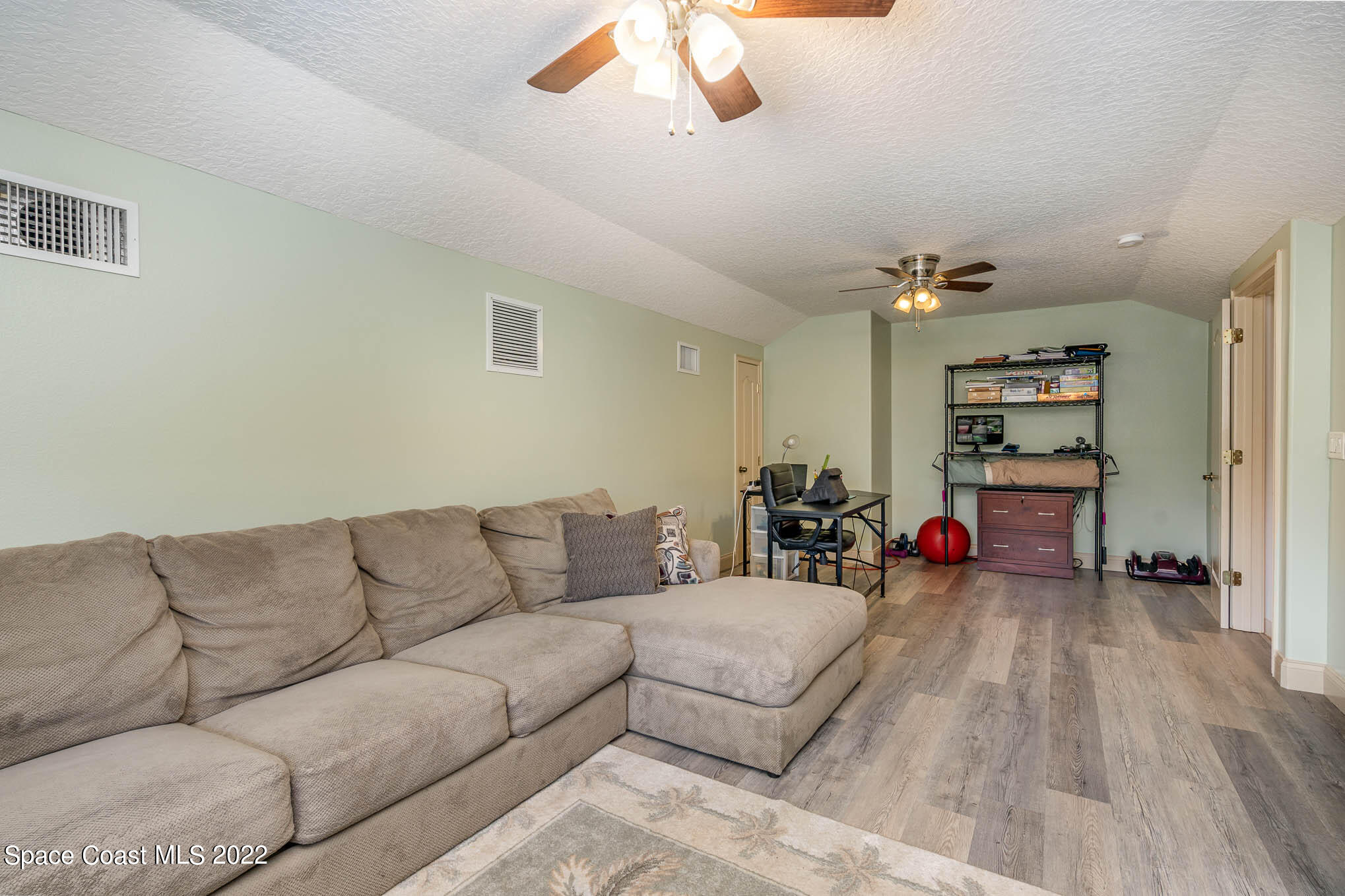 762 Seymour Road Northeast Palm Bay, FL 32905 - Photo 12 of 29 a living room with furniture and a wooden floor