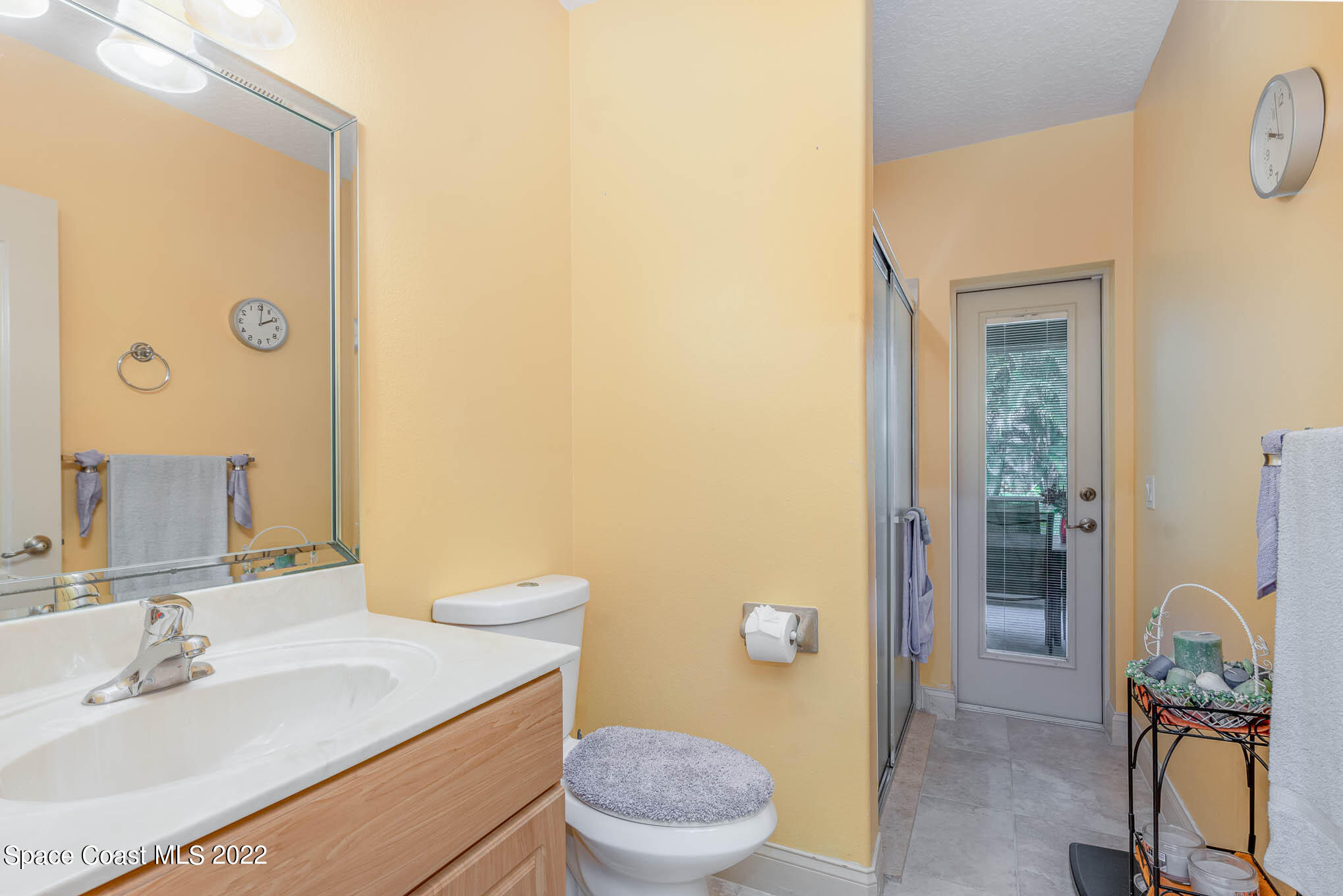 762 Seymour Road Northeast Palm Bay, FL 32905 - Photo 19 of 29 a bathroom with a granite countertop sink mirror vanity and toilet