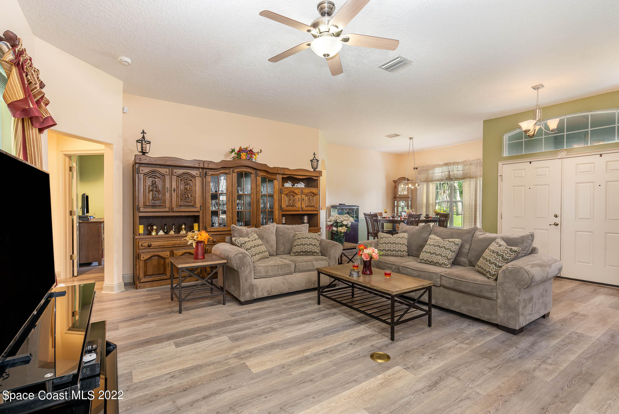 762 Seymour Road Northeast Palm Bay, FL 32905 - Photo 8 of 29 a living room with furniture kitchen view and a flat screen tv