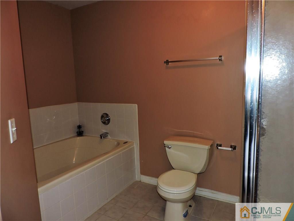 206 Hawthorne Road North Brunswick, NJ 08902 - Photo 14 of 24 a white toilet sitting next to a bathtub