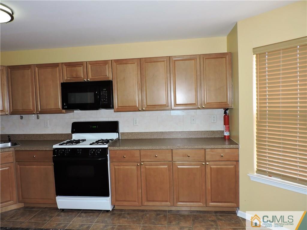 206 Hawthorne Road North Brunswick, NJ 08902 - Photo 7 of 24 a kitchen with stainless steel appliances granite countertop a stove a sink and a microwave
