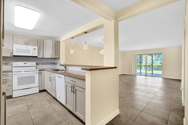 a kitchen with granite countertop white cabinets and white appliances
