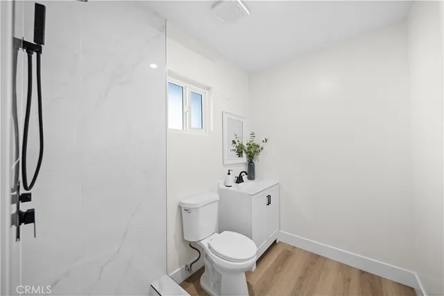 a white toilet sitting next to a bathroom sink and vanity