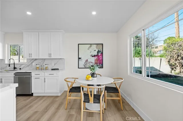 a kitchen with a dining table chairs and stove