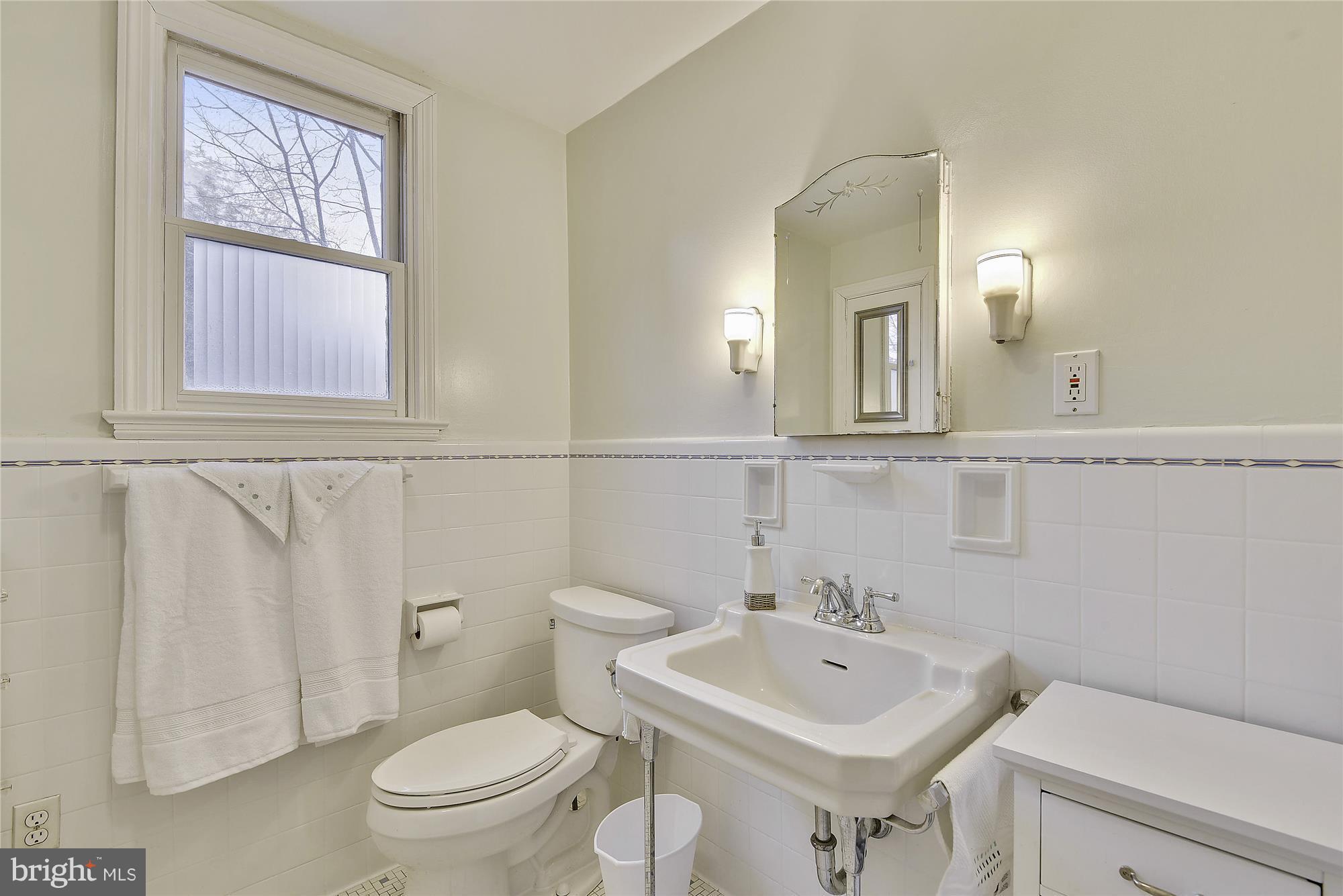 2200 Salisbury Road Silver Spring, MD 20910 - Photo 16 of 26 a bathroom with a toilet a sink and a mirror