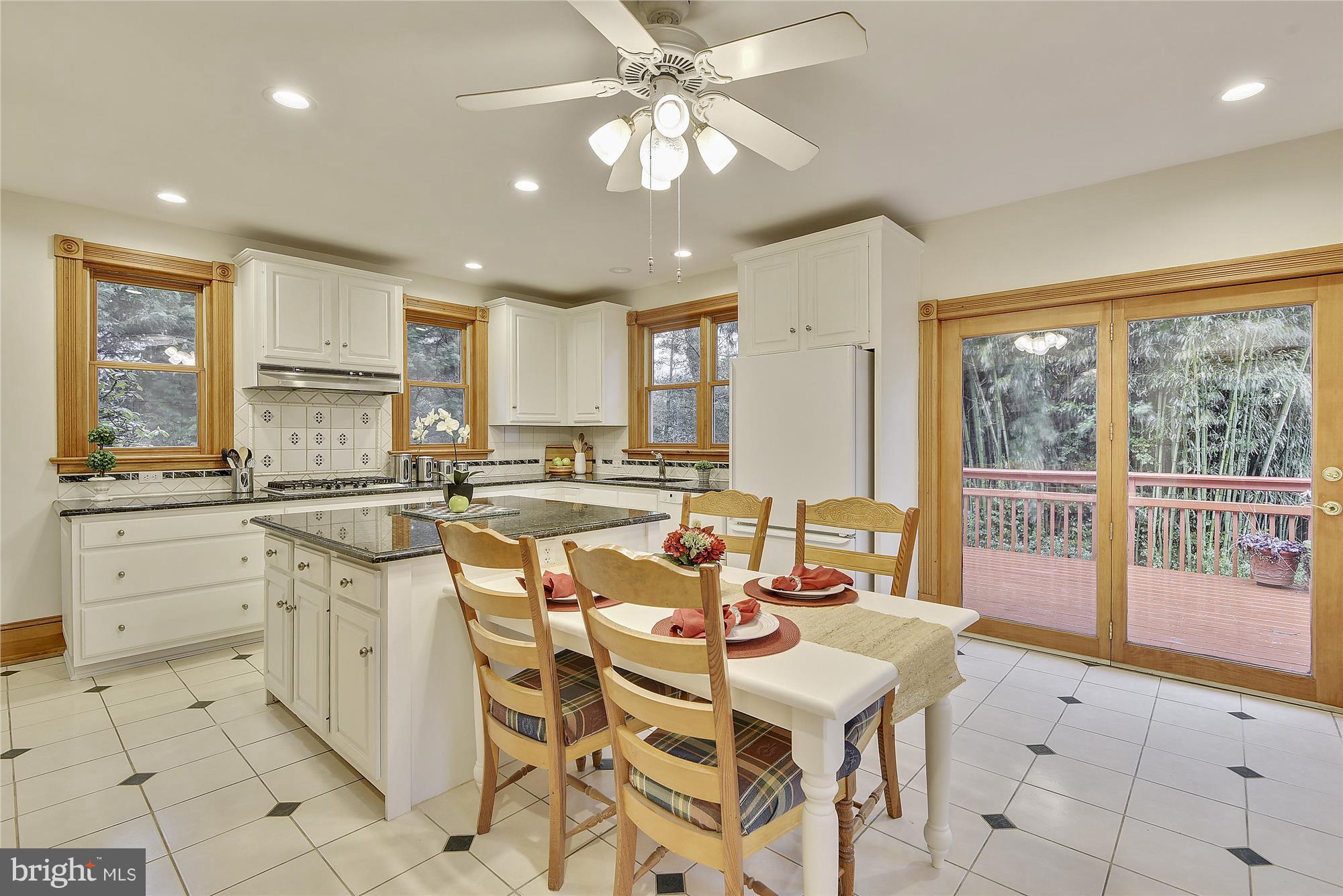 2200 Salisbury Road Silver Spring, MD 20910 - Photo 10 of 26 a kitchen with a stove a sink a dining table and chairs