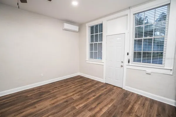 a view of empty room with wooden floor and windows