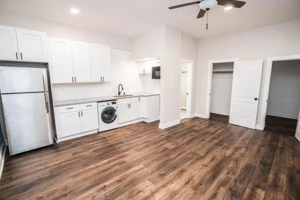 a view of a kitchen with a sink and dishwasher with wooden floor