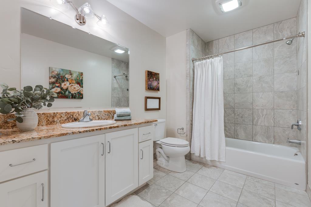 708 Frederick Street, Unit 204 Santa Cruz, CA 95062 - Photo 18 of 34 a bathroom with a granite countertop sink a toilet and a bathtub