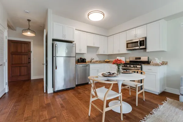 a kitchen with white cabinets and stainless steel appliances