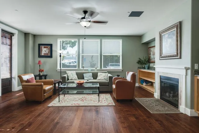 a living room with a fireplace and wooden floor