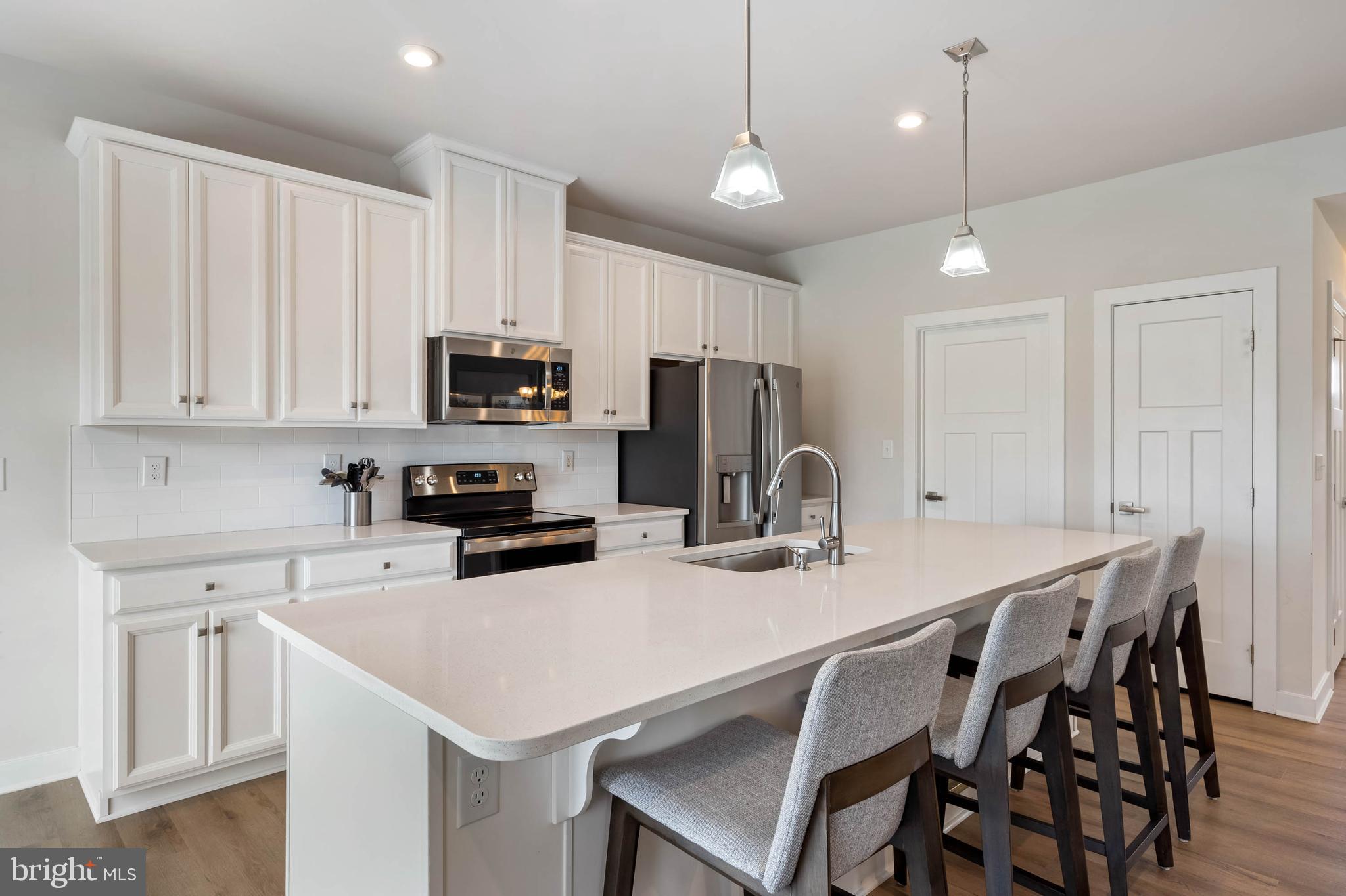 19016 Trimaran Drive Lewes, DE 19958 - Photo 12 of 44 a kitchen with kitchen island a appliances dining table and chairs