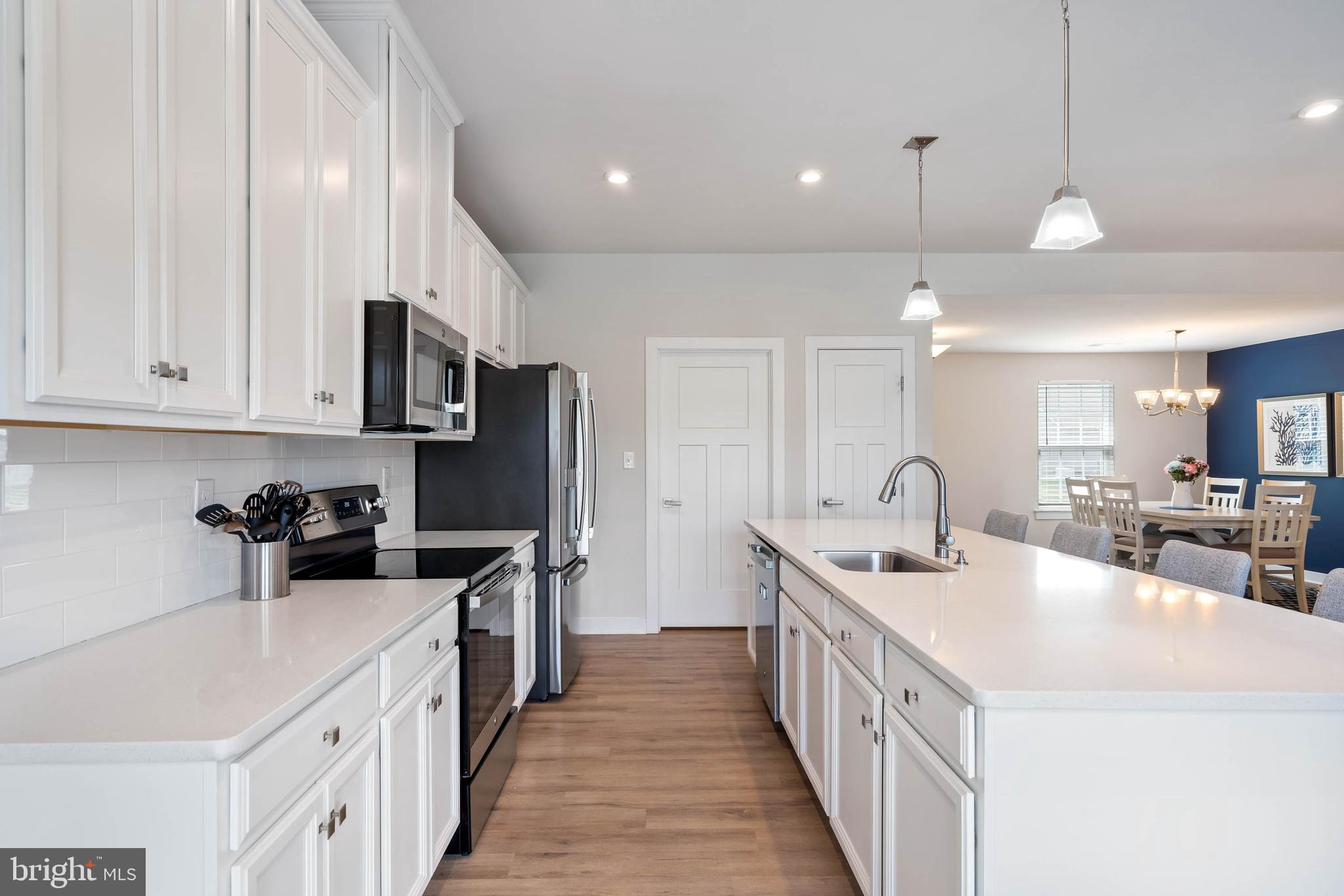 19016 Trimaran Drive Lewes, DE 19958 - Photo 13 of 44 a kitchen with stainless steel appliances a sink a stove top oven a counter space and cabinets