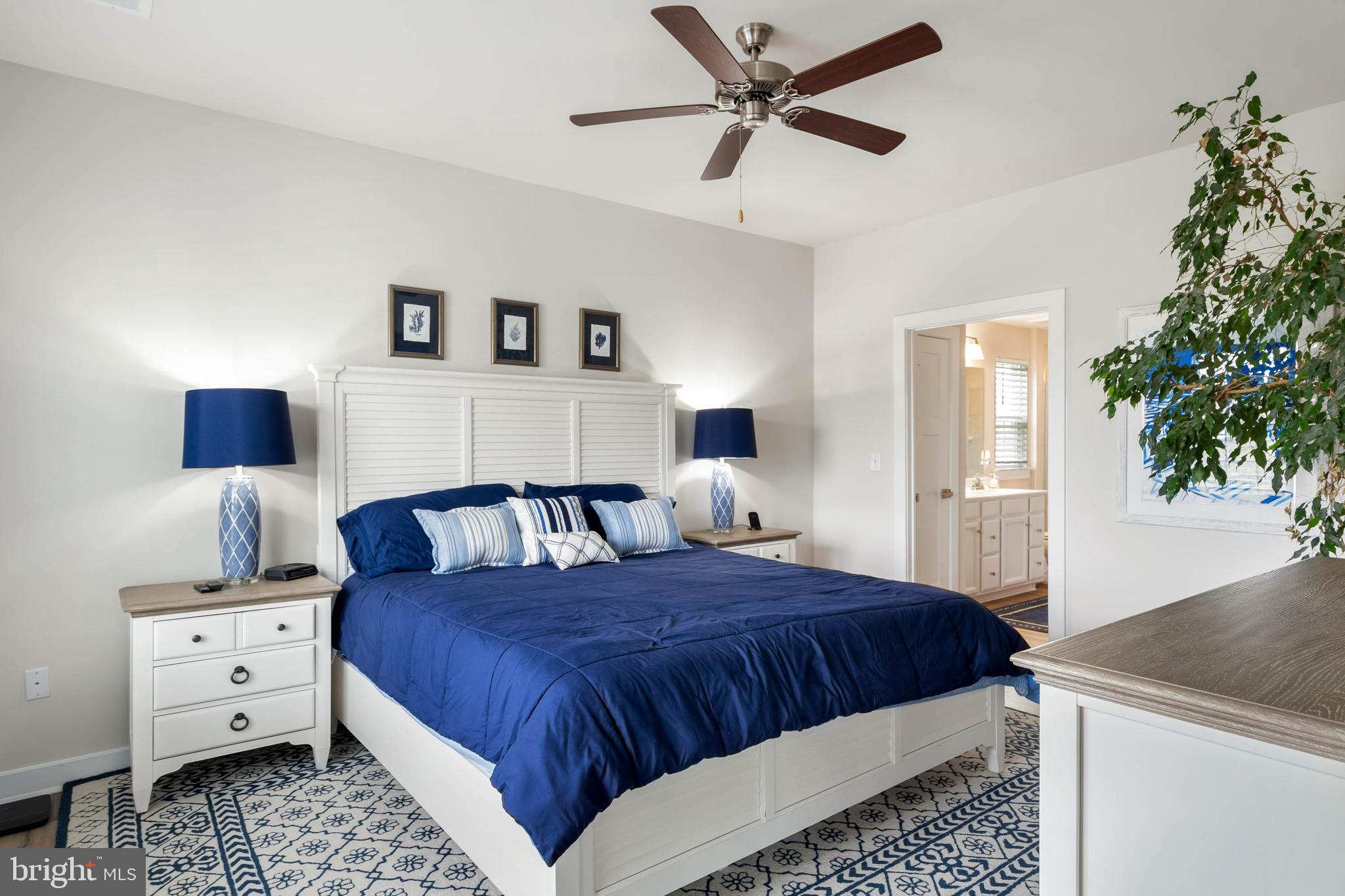 19016 Trimaran Drive Lewes, DE 19958 - Photo 18 of 44 a bedroom with a bed and a potted plant