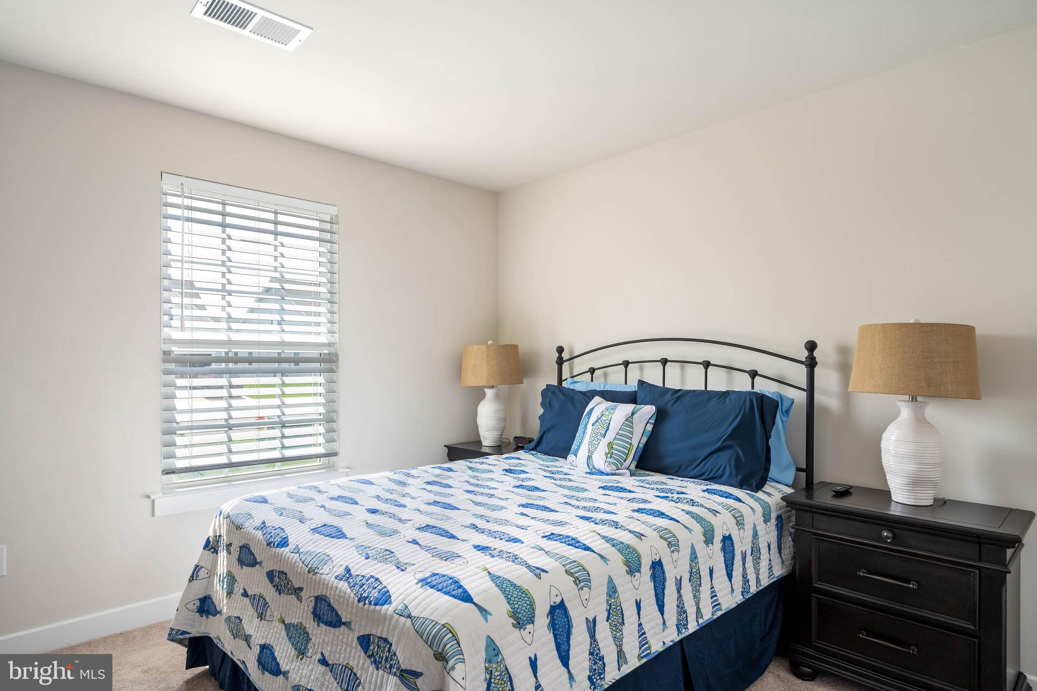 19016 Trimaran Drive Lewes, DE 19958 - Photo 24 of 44 a bedroom with a bed and a lamp with window