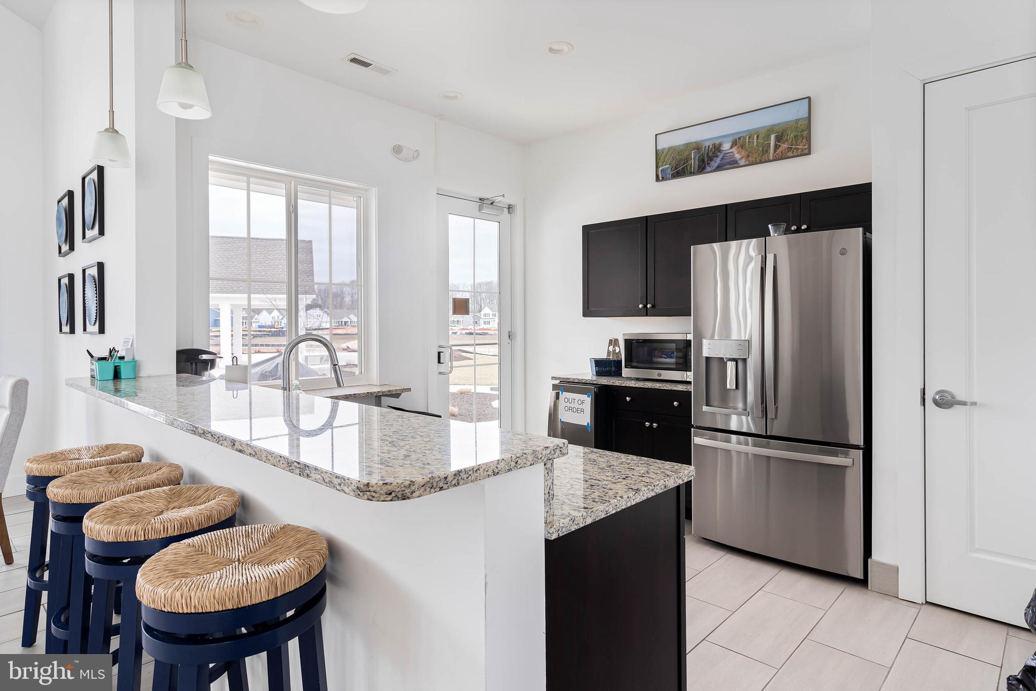 19016 Trimaran Drive Lewes, DE 19958 - Photo 40 of 44 a kitchen with granite countertop a refrigerator and a sink
