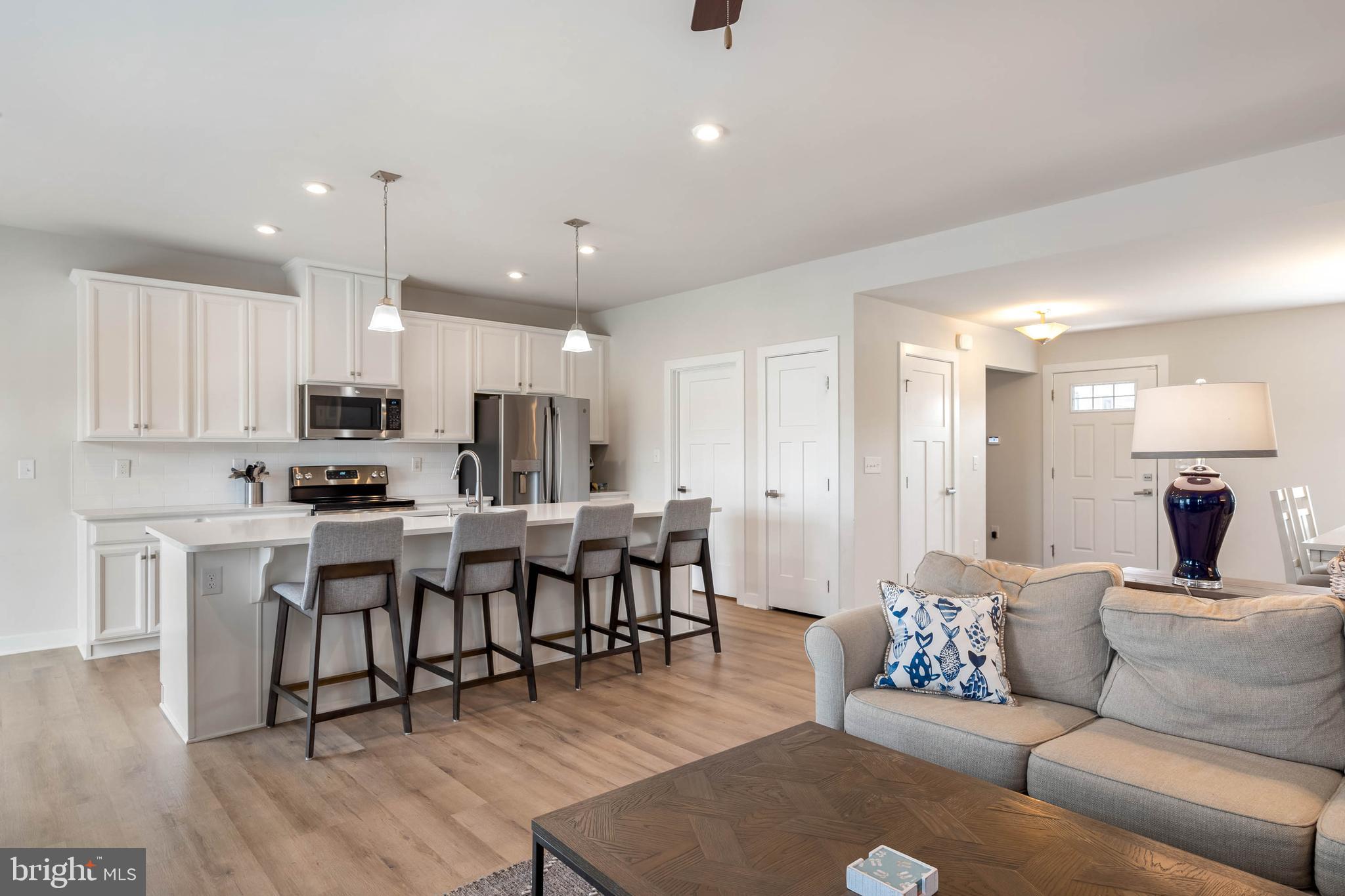 19016 Trimaran Drive Lewes, DE 19958 - Photo 10 of 44 a living room kitchen with a dining table wooden floor furniture and kitchen view