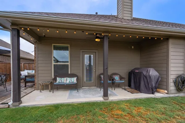 a view of a patio with table and chairs and a barbeque