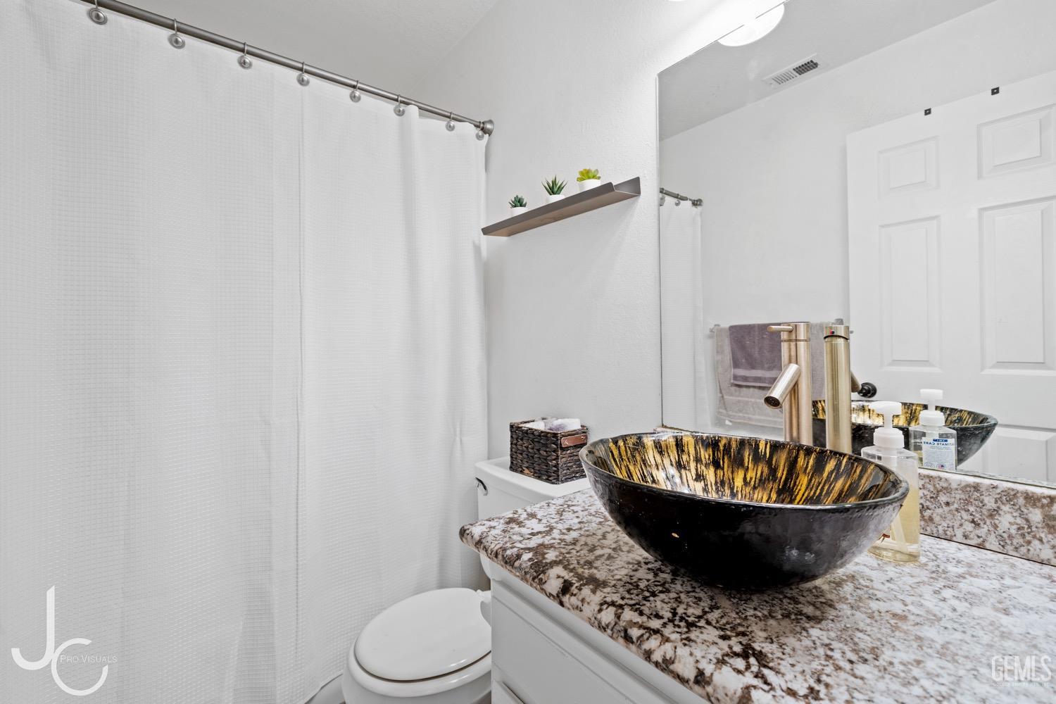 Undisclosed Address Bakersfield, CA 93311 - Photo 11 of 20 a room with a chandelier and a wooden floor