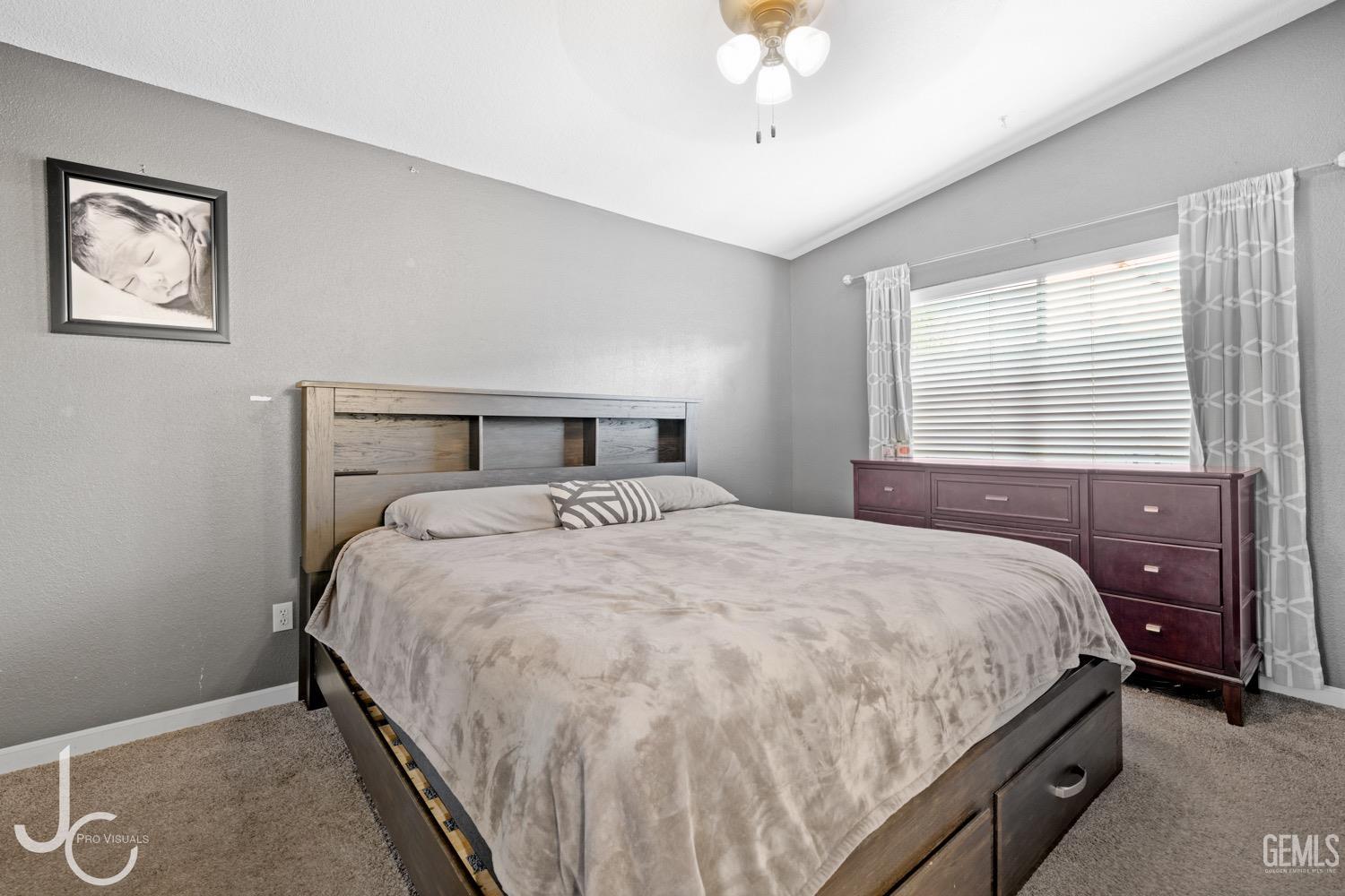 Undisclosed Address Bakersfield, CA 93311 - Photo 13 of 20 a bedroom with a bed and a chandelier