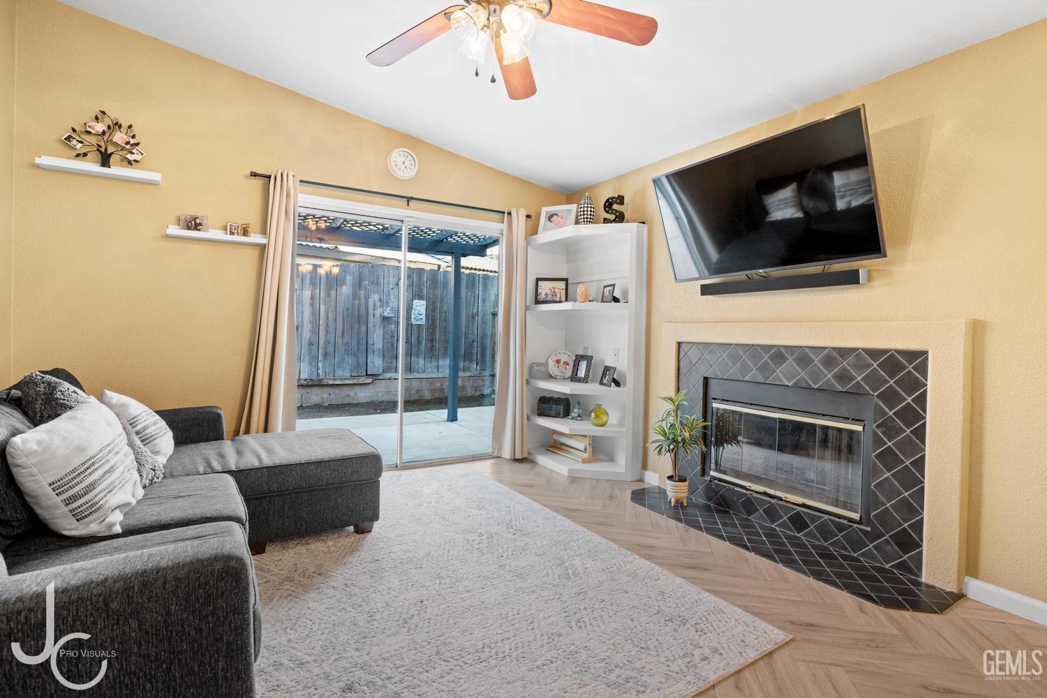 Undisclosed Address Bakersfield, CA 93311 - Photo 4 of 20 a living room with furniture a flat screen tv and a fireplace