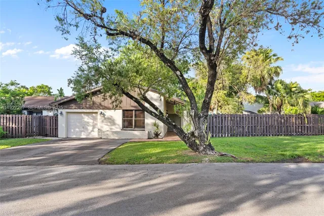 a front view of a house with a yard and trees