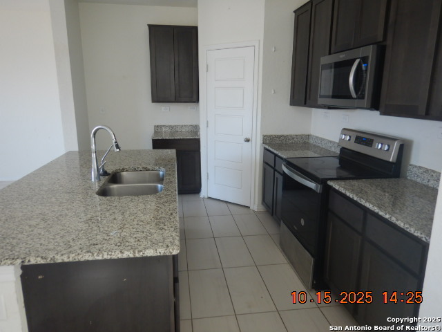 6555 Runaway Row Converse, TX 78109 - Photo 15 of 23 a kitchen with granite countertop a stove a sink and a microwave