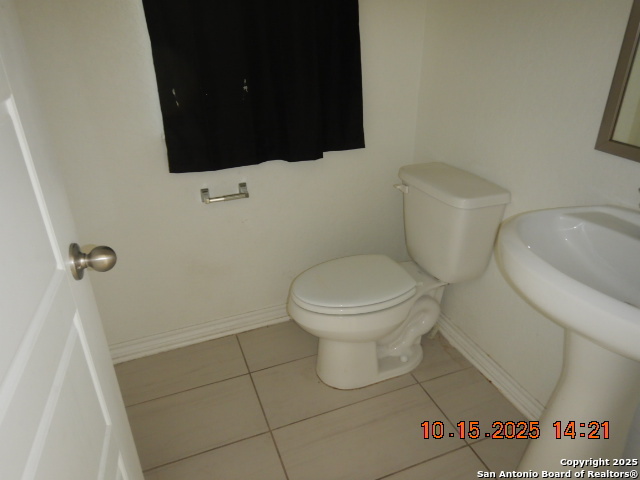 6555 Runaway Row Converse, TX 78109 - Photo 8 of 23 a white toilet sitting next to a bathroom sink and a mirror