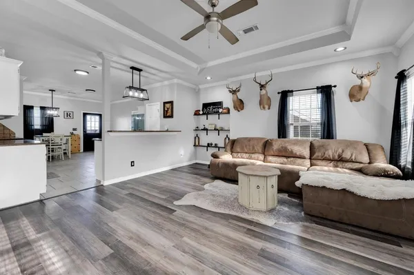 a living room with furniture and view of kitchen