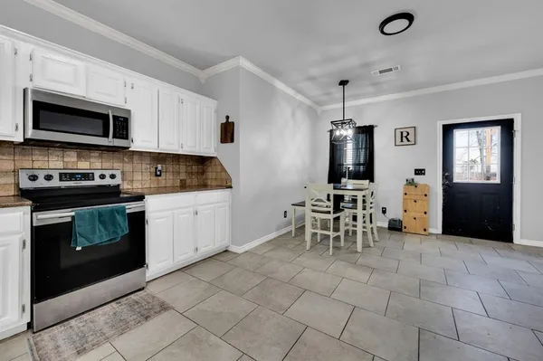 a kitchen with granite countertop a sink cabinets and stainless steel appliances