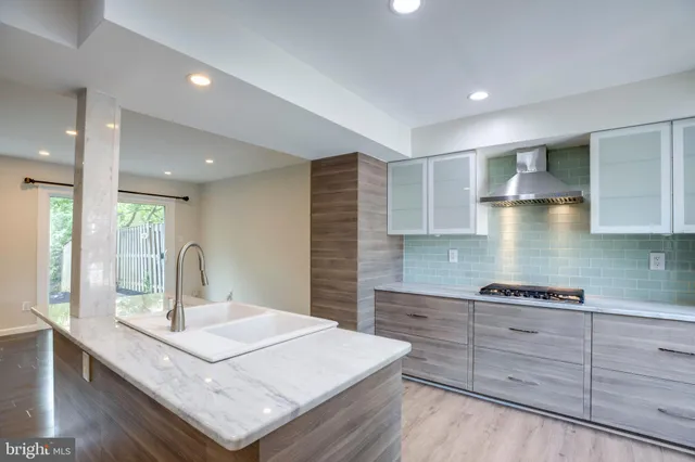 a kitchen with kitchen island a sink stove and cabinets