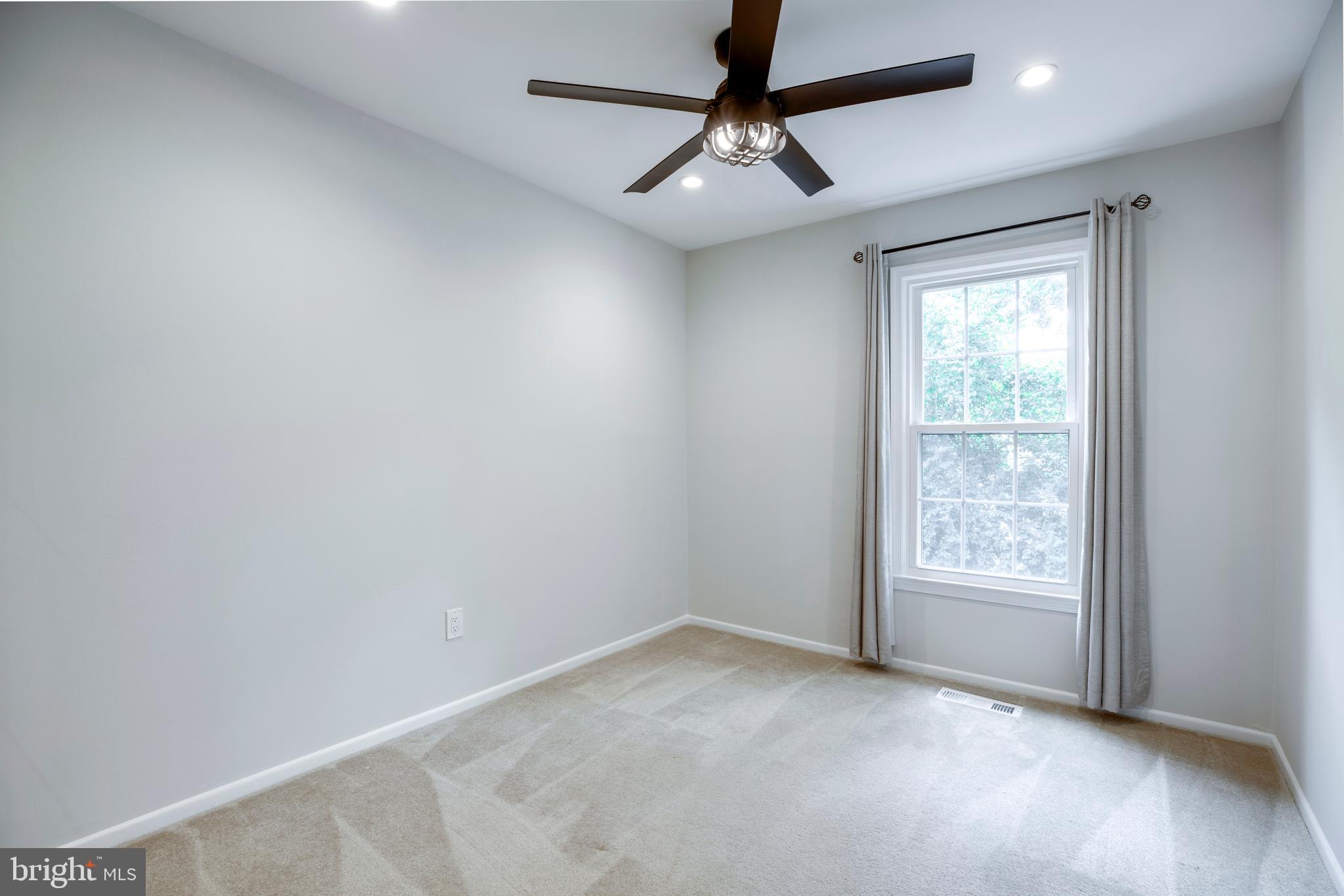 9513 Burdett Road Burke, VA 22015 - Photo 18 of 40 an empty room with a window and a fan