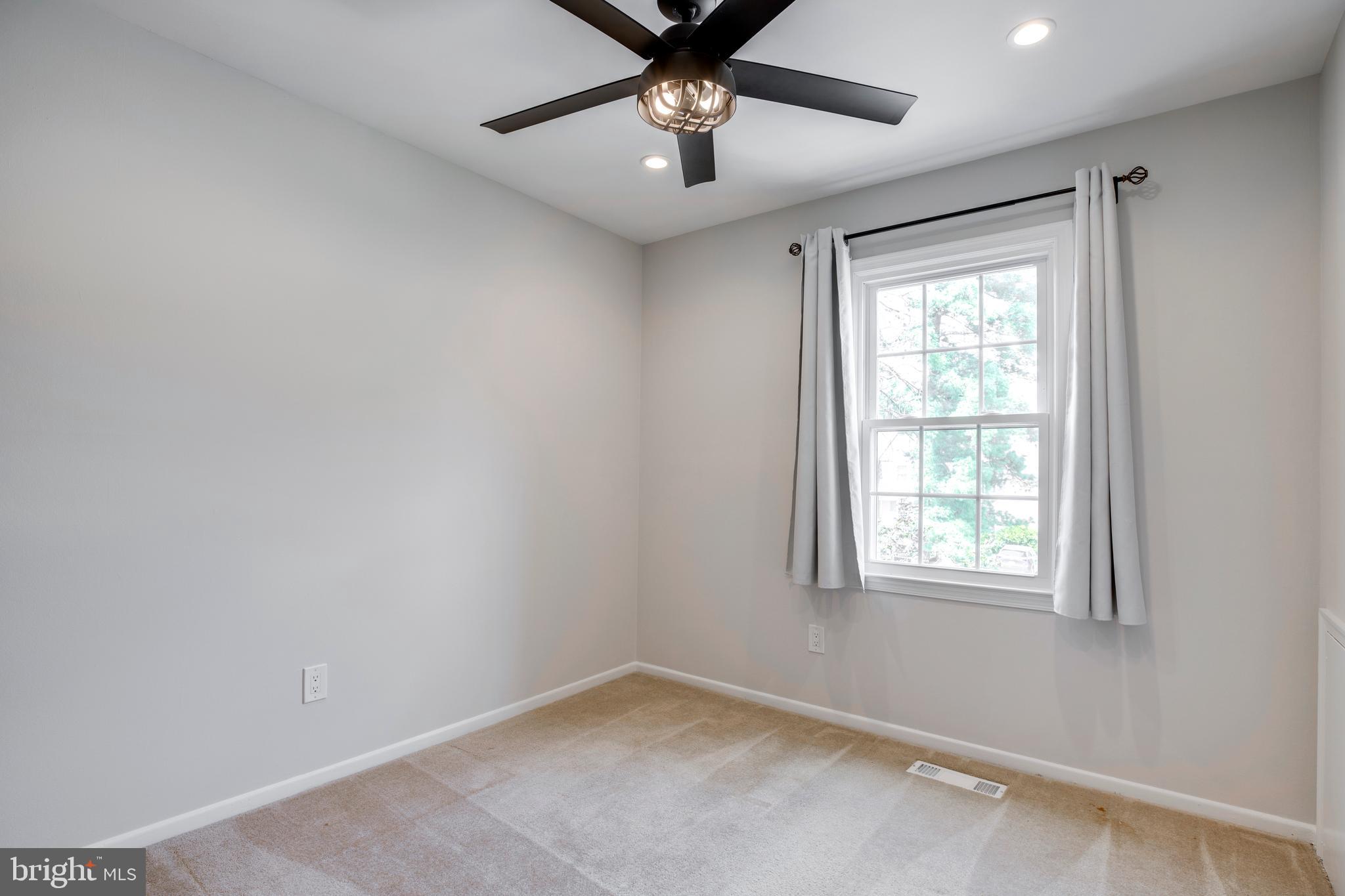 9513 Burdett Road Burke, VA 22015 - Photo 22 of 40 an empty room with windows and ceiling fan