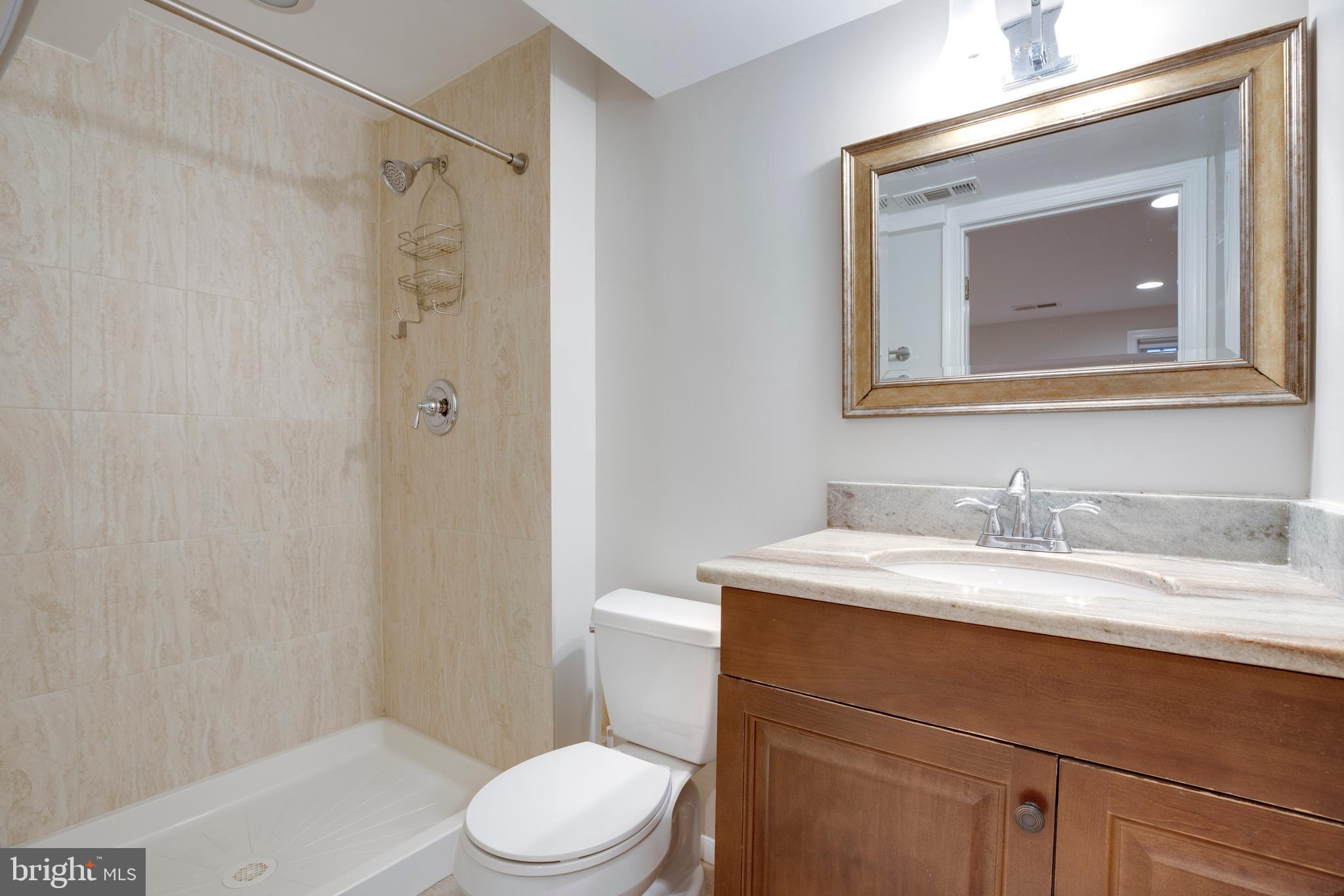 9513 Burdett Road Burke, VA 22015 - Photo 27 of 40 a bathroom with a granite countertop toilet sink and mirror