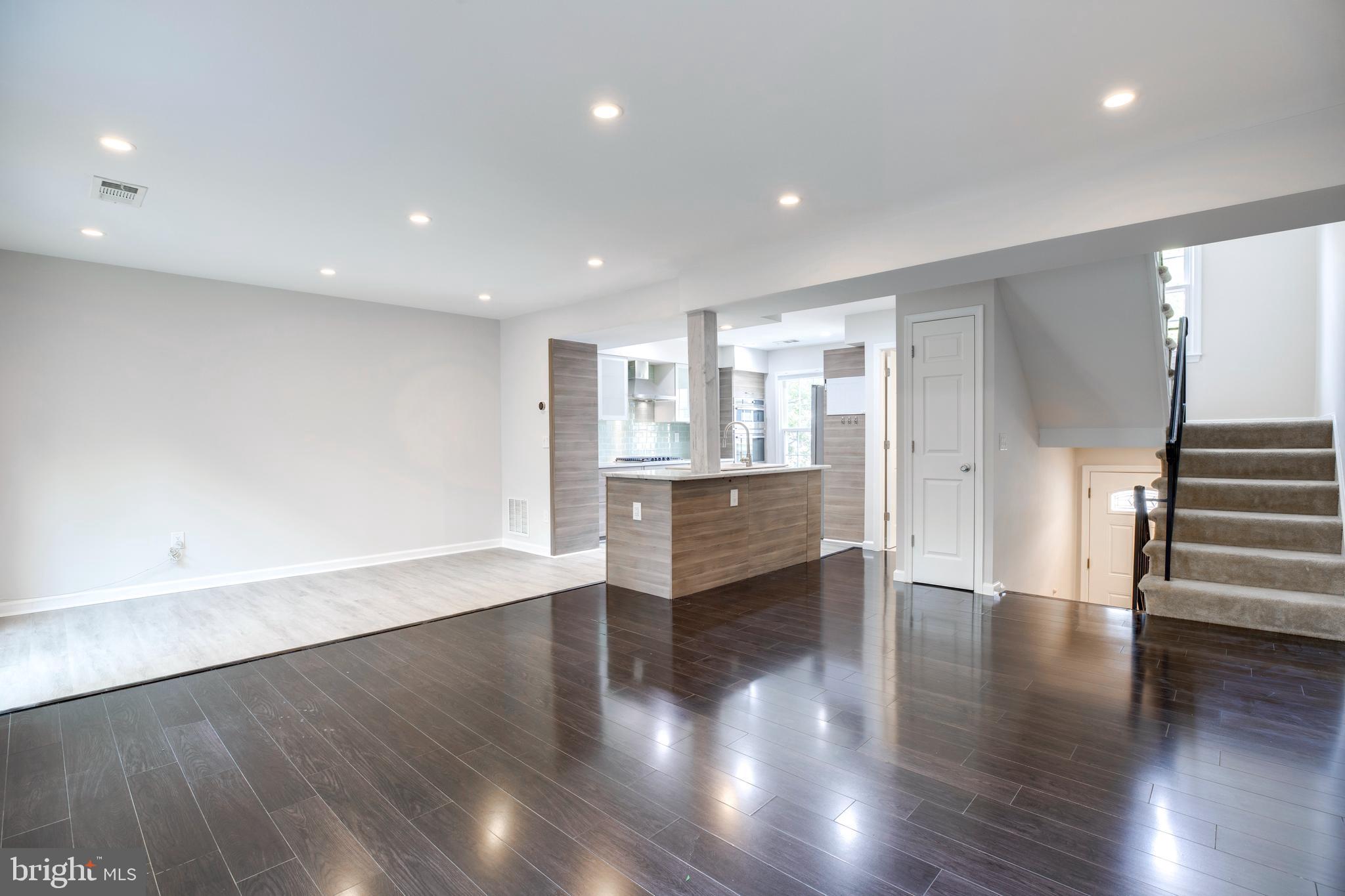 9513 Burdett Road Burke, VA 22015 - Photo 5 of 40 a view of an empty room with wooden floor and a kitchen