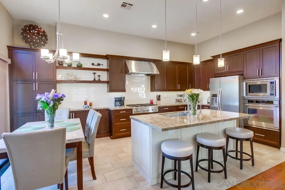 3396 Monique Lane Spring Valley, CA 91977 - Photo 13 of 51 a kitchen with granite countertop kitchen island stainless steel appliances a refrigerator and a dining table