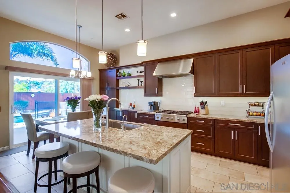 3396 Monique Lane Spring Valley, CA 91977 - Photo 17 of 51 a kitchen with stainless steel appliances granite countertop a stove a sink a microwave island and chairs