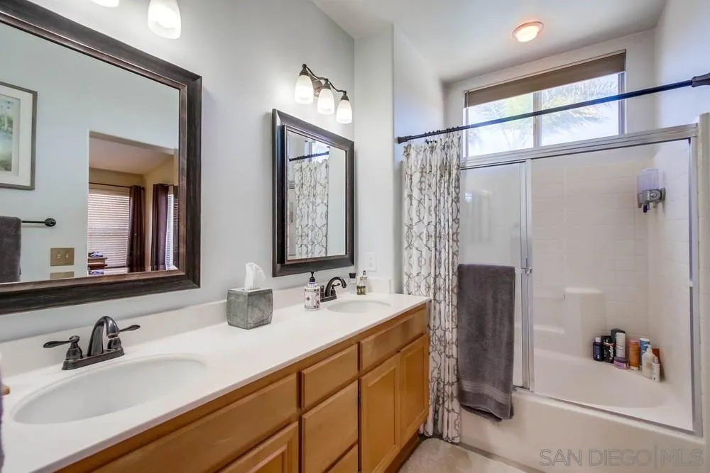 3396 Monique Lane Spring Valley, CA 91977 - Photo 30 of 51 a bathroom with a double vanity sink a mirror and shower