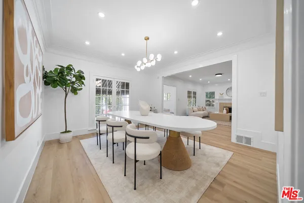 a dining room with wooden floor a glass table and chairs