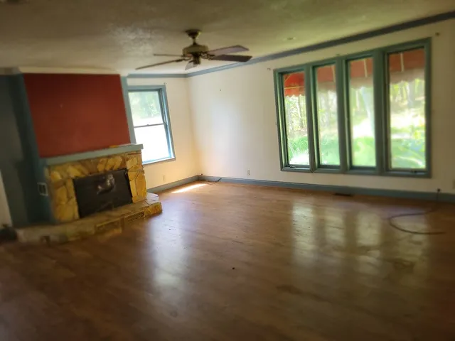 a view of a livingroom with furniture a fireplace and wooden floor